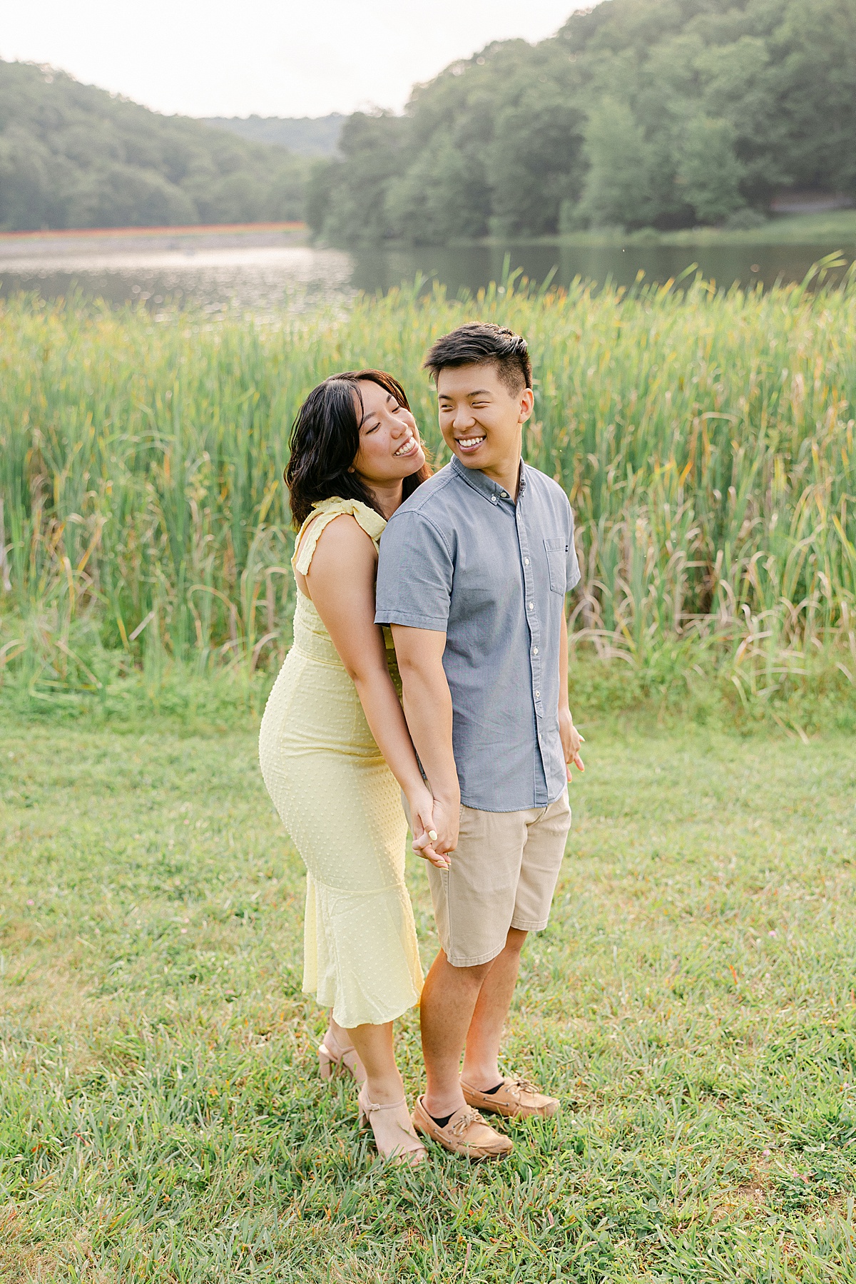 Engaged couple walking along Greenbrier Lake shore at golden hour in Boonsboro Maryland | Brittany Thomas Photography Maryland Wedding Photographer